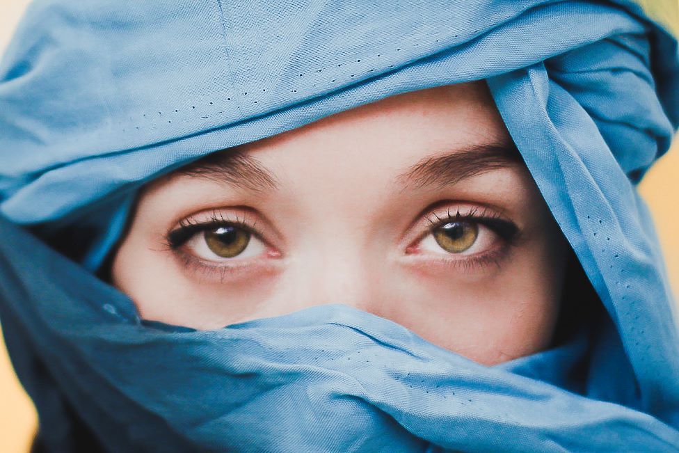 retrato de mujer ojos con pañuelo azul tapandole toda la cara menos los ojos 